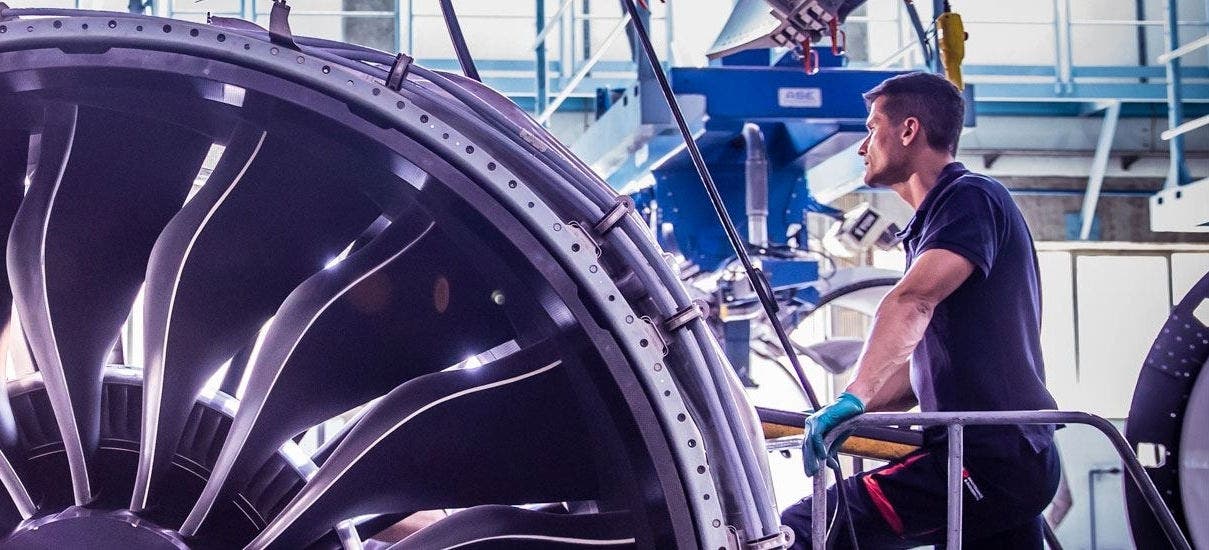 TAP Maintenance technician working on or inspecting an aircraft engine.