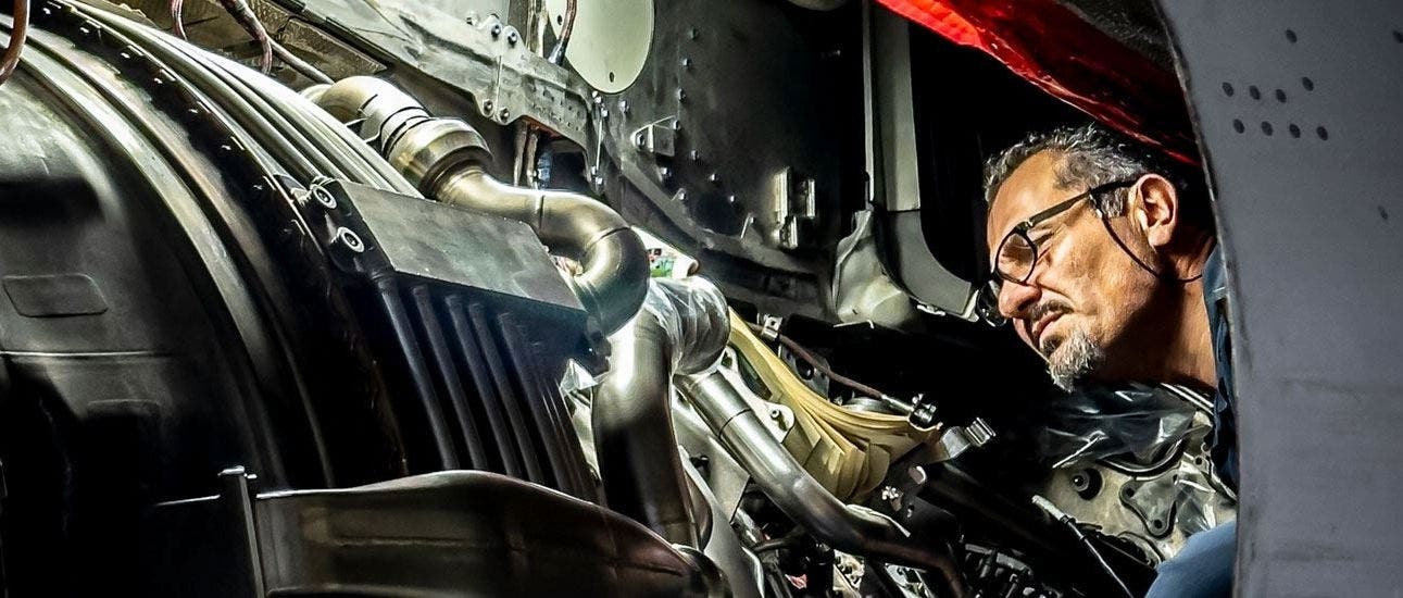 TAP Maintenance worker inspecting the inner components of a jet engine. 