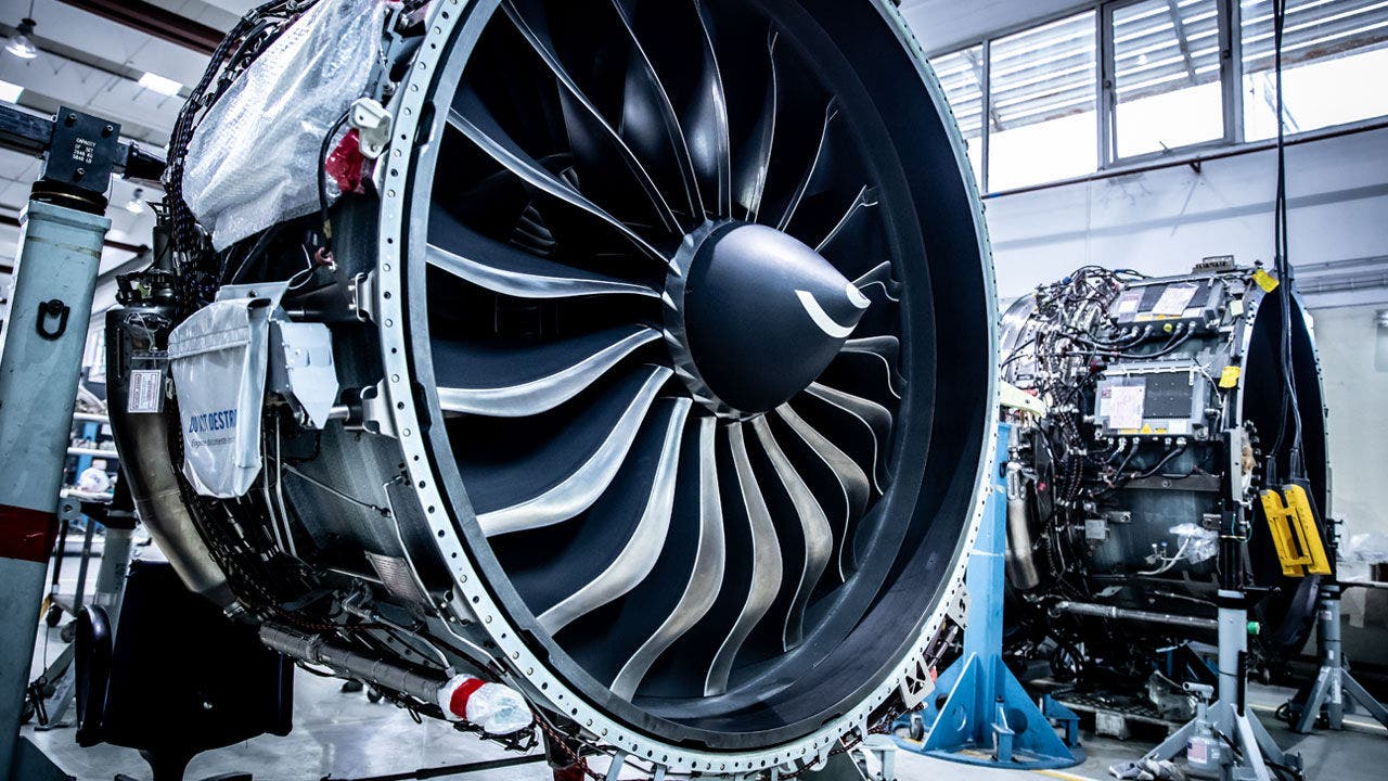 Close-up of a large aircraft jet engine inside a maintenance facility.